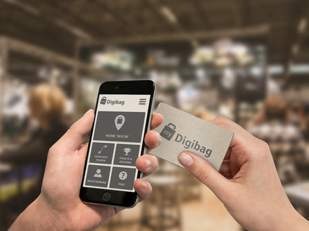 First Person View: Person nutzt die 'Digibag'-App und NFC-Karte auf einer Messe.